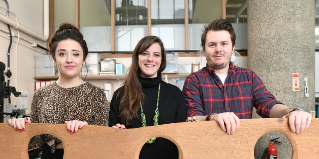Museum of London staff Maddie Hammond, Emily Brazee and Tom Kelly pictured with a replica of a 12th century triple toilet seat, before it goes on display as part of the Secret Rivers exhibition.