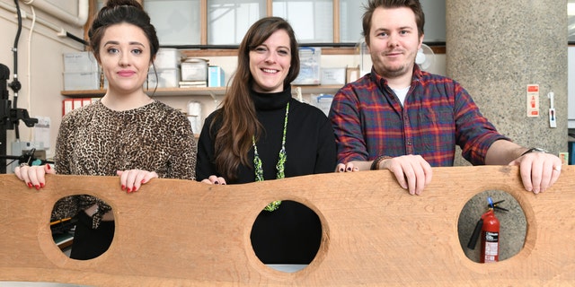 Museum of London staff Maddie Hammond, Emily Brazee and Tom Kelly pictured with a replica of a 12th century triple toilet seat, before it goes on display as part of the Secret Rivers exhibition.