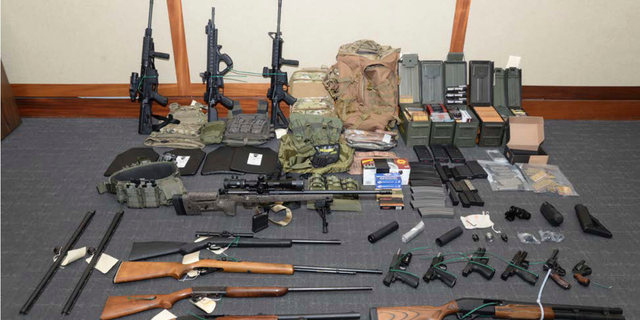 This image provided by the U.S. District Court in Maryland shows a photo of firearms and ammunition that was in the motion for detention pending trial in the case against Christopher Paul Hasson. Prosecutors say that Hasson, a Coast Guard lieutenant is a "domestic terrorist" who wrote about biological attacks and had a hit list that included prominent Democrats and media figures. He is due in court on Feb. 21 in Maryland. Prosecutors say Hasson espoused extremist views for years. Court papers say Hasson described an "interesting idea" in a 2017 draft email that included "biological attacks followed by attack on food supply." (U.S. District Court via AP)