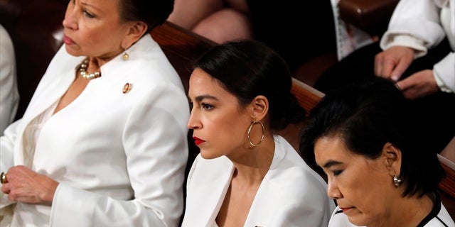 Rep. Alexandria Ocasio-Cortez, D-N.Y., center, listens as President Donald Trump delivers his State of the Union address to a joint session of Congress on Capitol Hill in Washington, Tuesday, Feb. 5, 2019. (AP Photo/J. Scott Applewhite)