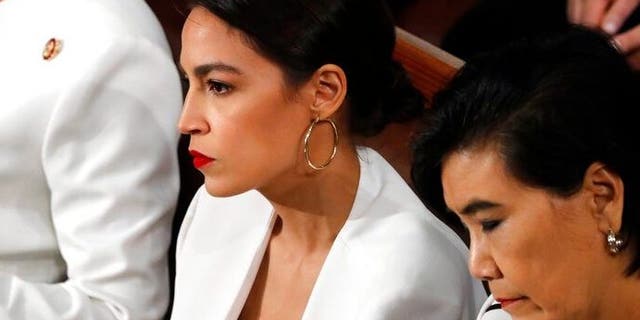 Rep. Alexandria Ocasio-Cortez, D-N.Y., center, listens as President Donald Trump delivers his State of the Union address to a joint session of Congress on Capitol Hill in Washington, Tuesday, Feb. 5, 2019. (AP Photo/J. Scott Applewhite)