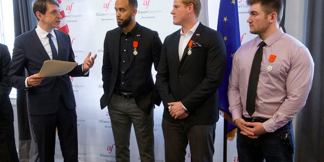 French Consul General Emmanuel Lebrun-Damiens, left, honors Spencer Stone, Anthony Sadler, and Alek Skarlatos during a French Naturalization Ceremony in Sacramento, Calif., Thursday, Jan. 31, 2019. The three men were heralded as heroes when they subdued an armed terrorist on a train in France in 2015. Today they were granted French citizenship. (AP Photo/Randall Benton)