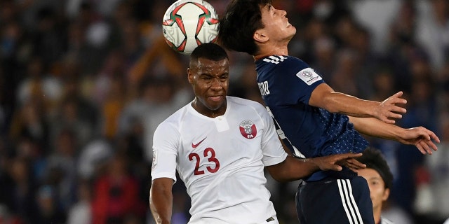 Japan's forward Takumi Minamino, right, challenges Qatar's defender Assim Madibo, left, during the AFC Asian Cup final match between Japan and Qatar in Zayed Sport City in Abu Dhabi, United Arab Emirates, Friday, Feb. 1, 2019.