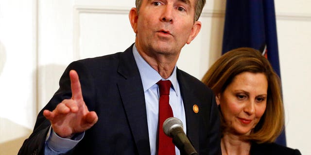 Virginia Gov. Ralph Northam, left, gestures as his wife, Pam, listens during a news conference in the Governors Mansion at the Capitol in Richmond, Va., Saturday, Feb. 2, 2019. Northam is under fire for a racial photo the appeared in his college yearbook. (AP Photo/Steve Helber)