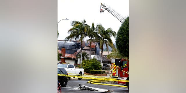 Firefighters work the scene of a deadly plane crash in the residential neighborhood of Yorba Linda, Calif.