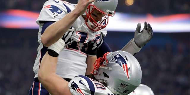 New England Patriots' David Andrews (60) picks up Tom Brady (12) after the Patriots scored a touchdown during the second half of the NFL Super Bowl VII against the Los Angeles Rams Sunday in Atlanta. (AP Photo/Jeff Roberson)