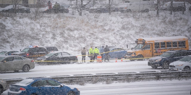 State Highway Patrol investigate the scene of a shooting on I-35W south Tuesday, Feb. 5, 2019, in Minneapolis. Authorities say a school bus driver was wounded in a shooting that followed a crash with another vehicle on a snowy interstate near downtown Minneapolis. (Jeff Wheeler/Star Tribune via AP)