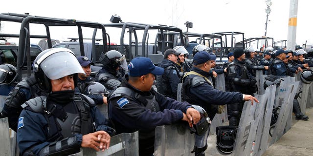 The Mexican Federal Police is guarding riot gear in front of a shelter for immigrant immigrants from Central America in Piedras Negras, Mexico on Tuesday, February 5, 2019. A caravan of about 1,600 migrants from Central America camped Tuesday in the Mexican border town of Piedras Negras, just west of Eagle Pass, Texas. The governor of Coahuila State in the north of the country described the migrants as "asylum seekers", suggesting that all had the express intention of surrendering to US authorities. (Jerry Lara / The San Antonio Express-News via AP)