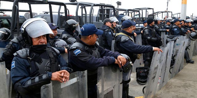 The Mexican Federal Police is guarding riot gear in front of a shelter for immigrant immigrants from Central America in Piedras Negras, Mexico on Tuesday, February 5, 2019. A caravan of about 1,600 migrants from Central America camped Tuesday in the Mexican border town of Piedras Negras, just west of Eagle Pass, Texas. The governor of Coahuila State in the north of the country described the migrants as "asylum seekers", suggesting that all had the express intention of surrendering to US authorities. (Jerry Lara / The San Antonio Express-News via AP)