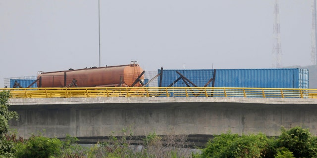 A fuel tanker, cargo trailers and makeshift fencing are used as barricades by Venezuelan authorities attempting to block humanitarian aid entering from Colombia on the Tienditas International Bridge that links the two countries as seen from the outskirts of Cucuta, Colombia, Wednesday, Feb. 6, 2019. Immigration authorities say the Venezuelan National Guard built the roadblock a day earlier.