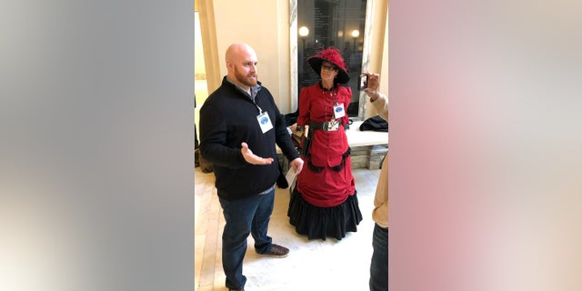 Alex Kearns and Belinda Barker, members of a pro-gun group, talk to a reporter, Thursday, Feb. 7, 2019, in Oklahoma City, after a House panel approved a bill that would allow Oklahomans to carry firearms without a permit, training or background check. (Associated Press)