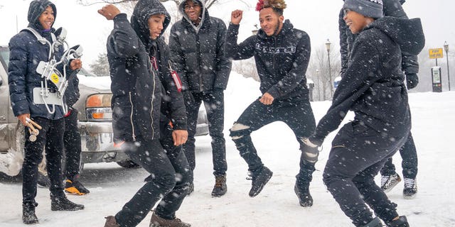 The combined North and Patrick Henry High School drum corps keeps warm in the parking lot Sunday, Feb. 10, 2019, before taking part in Sen. Amy Klobuchar's announcement to run for president from a snowy Boom Park, in Minneapolis. (Glen Stubbe/Star Tribune via AP)
