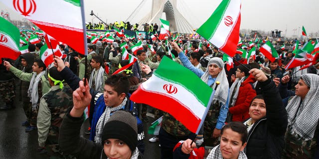 Children wave Iranian flags during a ceremony celebrating the 40th anniversary of the Islamic Revolution, at the Azadi, Freedom, Square in Tehran, Iran, Monday, Feb. 11, 2019.