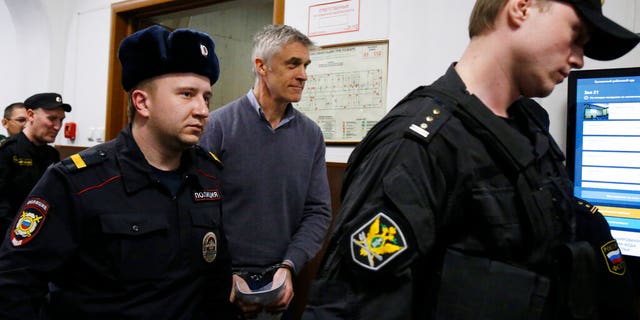 Founder of the Baring Vostok investment fund Michael Calvey, center, is escorted to the court room in Moscow, Russia, Friday, Feb. 15.