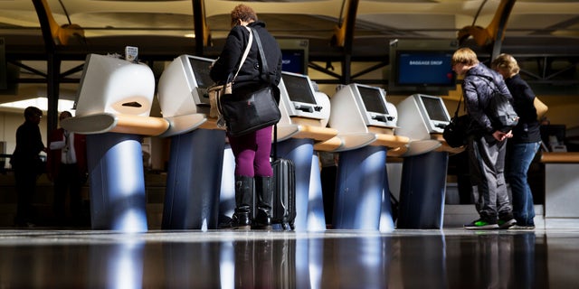 In this 2017 file photo, passengers check in for Delta Air Lines flights at airport kiosks. Major U.S. airlines say they will soon change their ticketing process to give passengers an option to identifying themselves as male or female.