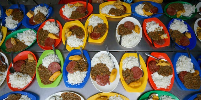 Free lunches prepped with lentils, a slice of bologna, rice and a piece of plantain ready to be served at a migrant shelter in La Parada, near Cucuta, Colombia, on the border with Venezuela, Monday. (AP Photo/Fernando Vergara)