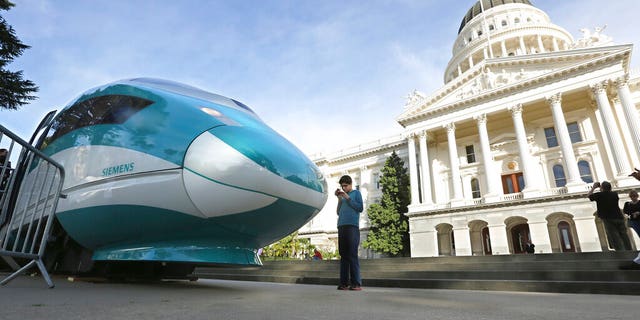 FILE - In this Feb. 26, 2015, file photo, a full-scale mock-up of a high-speed train is displayed at the Capitol in Sacramento, Calif. The Trump administration plans to cancel $929 million in U.S. money for California's beleaguered high-speed rail project and wants the state to return an additional $2.5 billion it's already spent. The U.S. Department of Transportation announcement Tuesday, Feb. 19, 2019, came after President Donald Trump last week threatened to make California pay back the money awarded to build the train between Los Angeles and San Francisco. (AP Photo/Rich Pedroncelli, File)