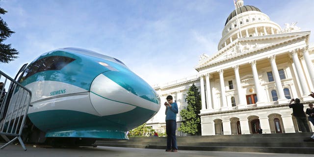 FILE - In this Feb. 26, 2015, file photo, a full-scale mock-up of a high-speed train is displayed at the Capitol in Sacramento, Calif. The Trump administration plans to cancel $929 million in U.S. money for California's beleaguered high-speed rail project and wants the state to return an additional $2.5 billion it's already spent. The U.S. Department of Transportation announcement Tuesday, Feb. 19, 2019, came after President Donald Trump last week threatened to make California pay back the money awarded to build the train between Los Angeles and San Francisco. (AP Photo/Rich Pedroncelli, File)