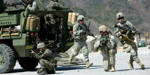 U.S. Army soldiers from the 25th Infantry Division's 2nd Stryker Brigade Combat Team and South Korean soldiers take their position during a demonstration of the combined arms live-fire exercise.