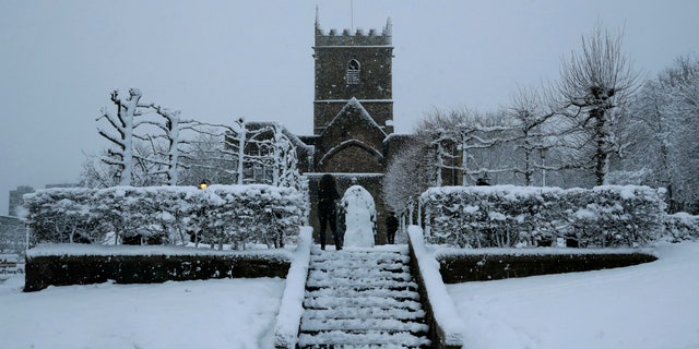 FILE - In this file photo dated Friday, Feb. 1, 2019, snow falls over St Peter's Church in Bristol, southwest England. The Church of England's governing Synod on Friday Feb. 22, 2019, lifted a 400-year-old rule requiring all churches to hold services every Sunday, acknowledging the reality of shrinking congregations and overworked priests. (AP Photo/Matt Dunham, FILE)