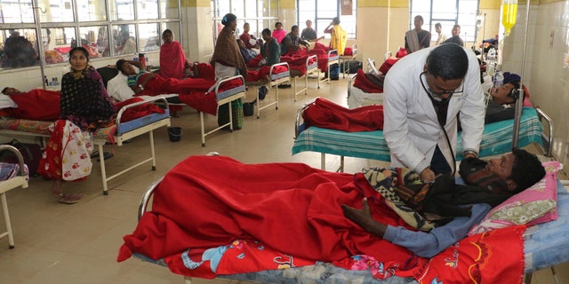 FILE - A doctor treats a victim, who had been consuming smuggled liquor, at a hospital in Jorhat, in India's northeastern state of Assam, on Saturday, February 23, 2019.