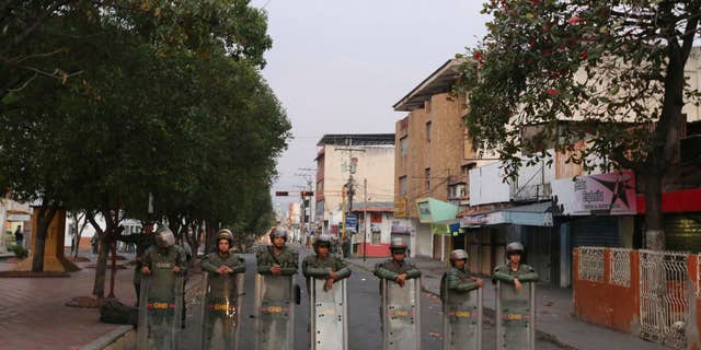 Venezuelan Bolivarian National Guards lineup to block the main entrance of Simon Bolivar bridge to Brazil