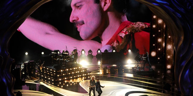 An image of Freddie Mercury appears on screen as Brian May, left, and Adam Lambert of Queen perform at the Oscars on Sunday, Feb. 24, 2019, at the Dolby Theatre in Los Angeles. (Photo by Chris Pizzello/Invision/AP)