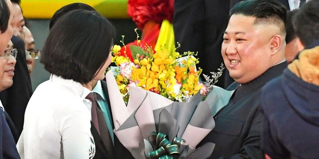 North Korean leader Kim Jong Un, right, receives bouquets on his arrival at the Dong Dang railway station in Dong Dang, a Vietnamese border town Tuesday.