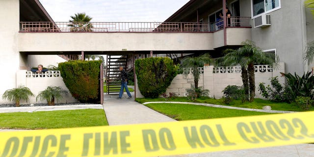 Residents mill about as Upland police investigate the scene, where police say a mother threw her young son from the second-story balcony of an apartment complex and then jumped herself as police arrived.