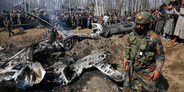 An Indian army soldier walks past the wreckage of an Indian aircraft after it crashed in Budgam area, outskirts of Srinagar, Indian controlled Kashmir, Wednesday, Feb.27, 2019.