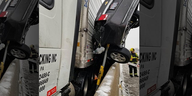 The left front end of the car, a dark Chevrolet Cruze, was pinned downward, with its back end pointed in the air.