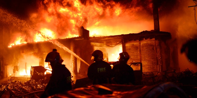 In this Wednesday, Feb. 20, 2019, photo, firefighters try to douse a fire in Dhaka, Bangladesh. A devastating fire raced through at least five buildings in an old part of Bangladesh's capital and killed scores of people. (AP Photo)