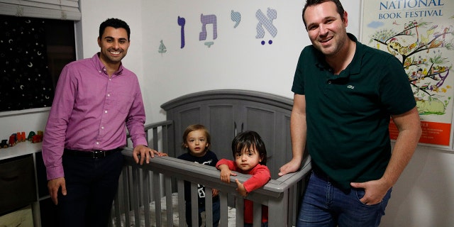 FILE - In the Tuesday, Jan. 23, 2018 file photo, Elad Dvash-Banks, left, and his partner, Andrew, pose for photos with their twin sons, Ethan, center right, and Aiden in their apartment in Los Angeles. (AP Photo/Jae C. Hong, File)