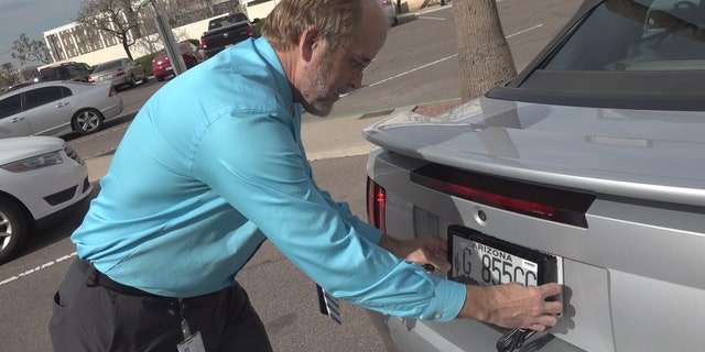 ADOT spokesman, Doug Nick, showing Fox News where the digital license plates would be placed, in the same location as the traditional metal plates