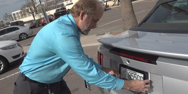 ADOT spokesman, Doug Nick, showing Fox News where the digital license plates would be placed, in the same location as the traditional metal plates