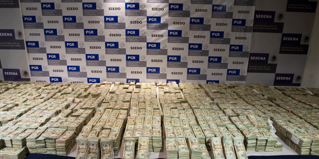 FILE - In this Sept. 18, 2008, file photo, cash seized by Mexico's Army, which according to the Defense Department was seized on Sept. 14 from the Sinaloa drug cartel and is displayed to the press in Mexico City. Federal authorities have said they want to go after an estimated $14 billion fortune for the Mexican drug lord known as El Chapo, who was head of the cartel. (AP Photo/Eduardo Verdugo, File)
