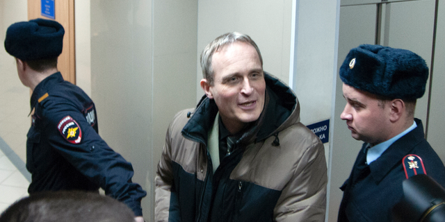 Danish Jehovah's Witness Dennis Christensen is escorted from a courtroom in Russia in February. (Yuriy Temirbulatov, Courtesy of Jehovah's Witnesses via AP)