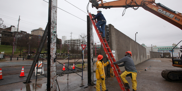 Workers with the City of Vicksburg start construction on one of the three flood wall gates on Levee Street in Vicksburg Miss., on Thursday Feb. 21, 2019. According to the National Weather Service the Mississippi River is currently at 44.69 feet and is expected to reach 48.9 feet. (Courtland Wells/The Vicksburg Post, via AP)