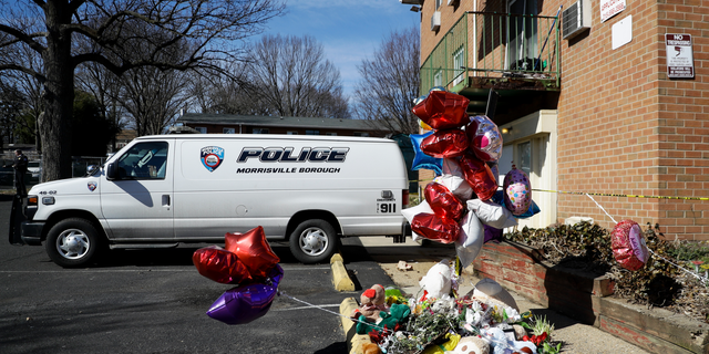 A makeshift memorial is seen outside the Robert Morris Apartments, Thursday, Feb. 28, 2019, in Morrisville, Pa. A mother and her adult daughter killed five of their close relatives, including three children, and were found "disoriented" after child welfare authorities arrived for a surprise visit to their trashed apartment outside Philadelphia, police and prosecutors said Tuesday. (AP Photo/Matt Slocum)