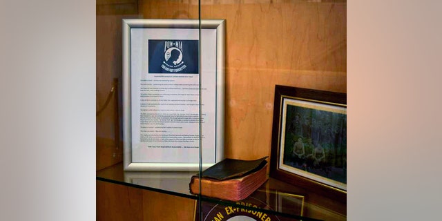 In this photo provided by the Office of Public Affairs, Manchester VA Medical Center, a Bible is displayed at the Manchester VA Medical Center in Manchester, N.H. Two organizations are fighting over the display of the Bible at the medical center. The Bible was carried by a prisoner of war in World War II and became part of a memorial and was later removed after the Military Religious Freedom Foundation objected. WMUR-TV reports another group, the Northeast POW-MIA Network, wants to put it back. (Office of Public Affairs, Manchester VA Medical Center via AP)