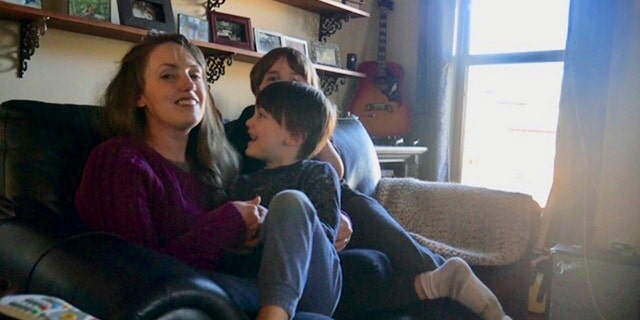 In this 2019 photo provided by Americans United for Separation of Church and State, Aimee Maddonna smiles while sitting with her children at her home in Simpsonville, S.C. The South Carolina mother has sued both the state and federal government, saying she’s a victim of religious discrimination on the part of a federally funded foster-care agency that turned her down because of her Catholic faith. Maddonna says the agency in 2014 initially encouraged her to become a foster parent but cut off ties once realizing that she is Catholic and not a “born-again” Christian, as the agency’s internal rules require. (Courtesy of Aimee Maddonna/Americans United for Separation of Church and State via AP)