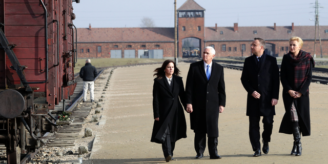United States Vice President Mike Pence and his wife Karen Pence, left, walk with Poland's President Andrzej Duda and his wife Agata Kornhauser-Duda, right, during their visit at the Nazi concentration camp Auschwitz-Birkenau in Oswiecim, Poland, Friday, Feb. 15, 2019. (AP Photo/Michael Sohn)