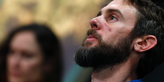 Travis Kauffman responds to questions during a news conference Thursday, Feb. 14, 2019, in Fort Collins, Colo., about his encounter with a mountain lion while running a trail just west of Fort Collins last week. Kaufman's girlfriend, Annie Bierbower, looks on. (AP Photo/David Zalubowski)