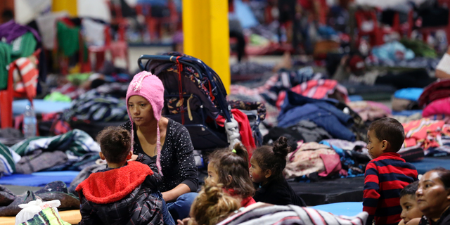 Honduran Delia Romero, 24, sits with her children in their sleeping area at a sheltered in Piedras Negras, Mexico, Tuesday, Feb. 5, 2019. A caravan of about 1,600 Central American migrants camped Tuesday in the Mexican border city of Piedras Negras, just west of Eagle Pass, Texas. The governor of the northern state of Coahuila described the migrants as "asylum seekers," suggesting all had express intentions of surrendering to U.S. authorities. (Jerry Lara/The San Antonio Express-News via AP)