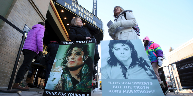 Brenda Jenkyns and Catherine Van Tighem stand with signs outside of the premiere of the "Leaving Neverland" documentary film at the Egyptian Theatre on Main Street during the 2019 Sundance Film Festival in Park City, Utah, on Jan. 25, 2019. (Photo by Danny Moloshok/Invision/AP, File)