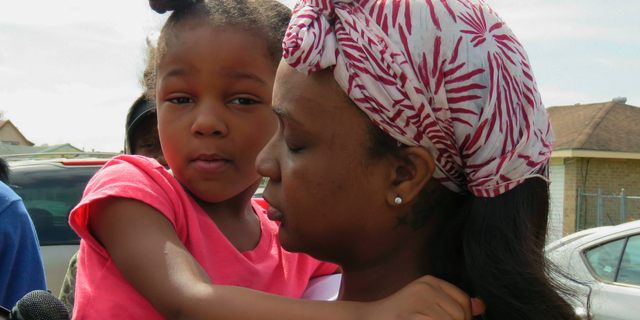 Markia Thomas, of Marrero, La., holds her daughter as she talks to reporters Thursday, Feb. 14, 2019, about the death of her 9-year-old son, Marquis Thomas Jr., the previous night. Marquis was accidentally shot in the head and killed Wednesday night when an 18-year-old cousin tried to get his gun away from the youngster, a Louisiana sheriff said. (AP Photo/Janet McConnaughey)