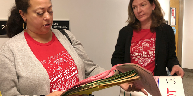 Eyana Spencer, principal at Manzanita Community School, left, and Katherine Carter, a principal at Oakland School of Language, look over their schedule for meeting with California lawmakers about Oakland school funding during a visit to the Capitol in Sacramento, Calif., Wednesday, Feb. 20, 2019. The principals are not striking but support better pay for teachers. Teachers in Oakland, Calif., prepared Wednesday to walk off the job in what could be the nation's latest strike over classroom conditions and pay. (AP Photo/Kathleen Ronayne)