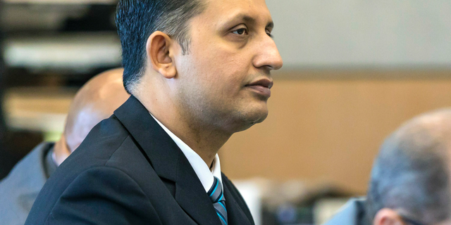 Former Palm Beach Gardens police officer Nouman Raja listens to defense attorney Scott Richardson give opening statements in Raja's trial, Tuesday, Feb. 26, 2019, in West Palm Beach, Fla. Raja is charged with the fatal 2015 shooting of a stranded black motorist, 31-year-old Corey Jones. (Lannis Waters/Palm Beach Post via AP, Pool)
