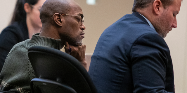 Quinn James, left, listens during Assistant Kent County Prosecutor Kellee Koncki's closing argument during his murder trial at the Kent County Courthouse in Grand Rapids on Wednesday, Feb. 27, 2019. James, accused of killing East Kentwood High student Mujey Dumbuya, 16, after she accused him of rape, is on trial this week charged with first-degree murder. (Cory Morse/The Grand Rapids Press via AP)