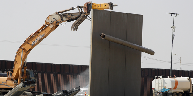 The top tube of a border wall prototype falls during demolition at the border between Tijuana, Mexico, and San Diego, Wednesday, Feb. 27, 2019, in San Diego. The government is demolishing eight prototypes of Donald Trump's prized border wall that instantly became powerful symbols of his presidency when they were built nine months after he took office. (AP Photo/Gregory Bull)